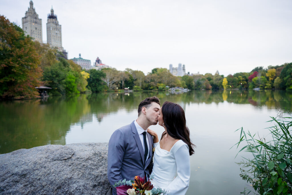 Skyline views of Central Park with wedding couple by the lake